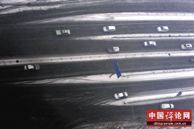 车辆行驶在郑州市的道路上。河南省气象台发布道路结冰黄色预警信号，雪雨天气影响返程并不利于城市早高峰交通。新华社发