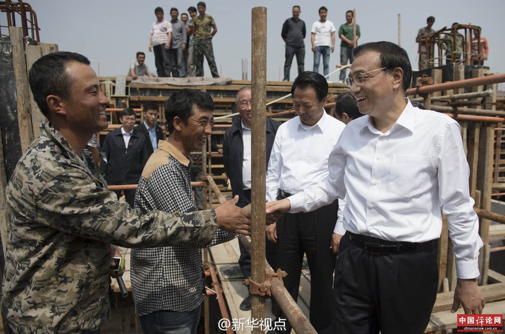 5月22日，在赤峰污水处理项目工地，李克强走上脚手架与农民工交谈。