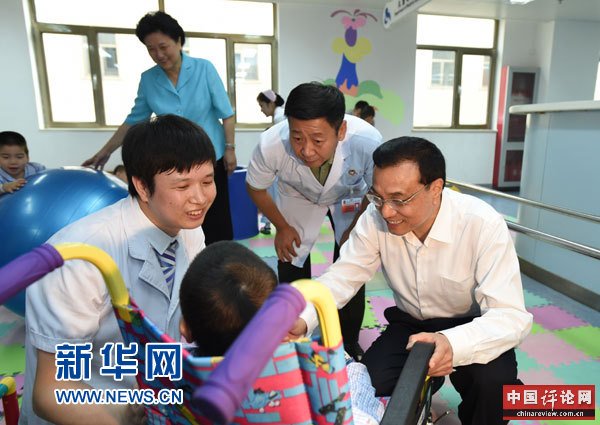 这是李克强与康复中的患儿交谈。 新华社记者马占成摄