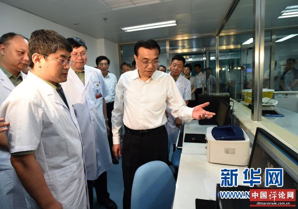 这是李克强向医务人员了解有关残疾孤儿治疗的情况。 新华社记者马占成摄