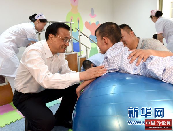 这是李克强与进行康复训练的患儿交谈。 新华社记者马占成摄
