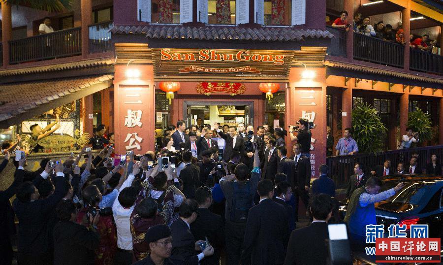 这是在三叔公特产店外，李克强向人群挥手致意。新华社记者 黄敬文 摄 