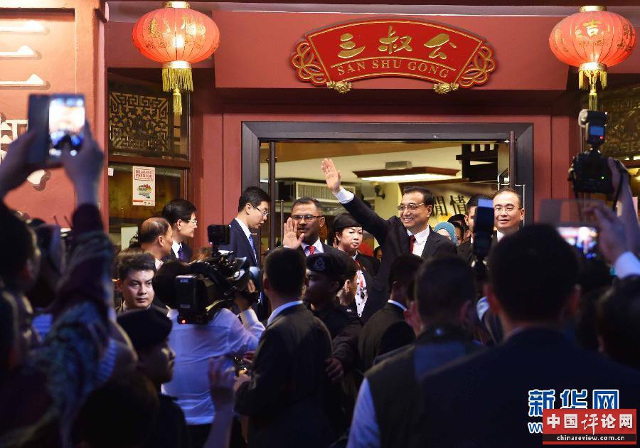 这是在三叔公特产店外，李克强向人群挥手致意。新华社记者 高洁 摄 